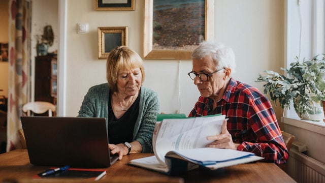 Senior couple using laptop at home 